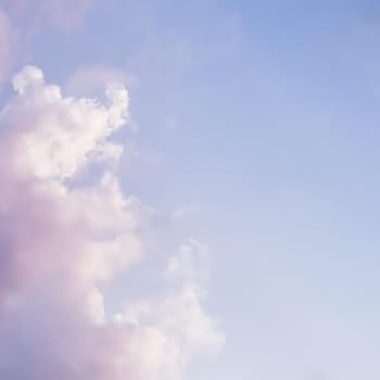 Blue sky background with white and pink clouds at sunset. High quality photo