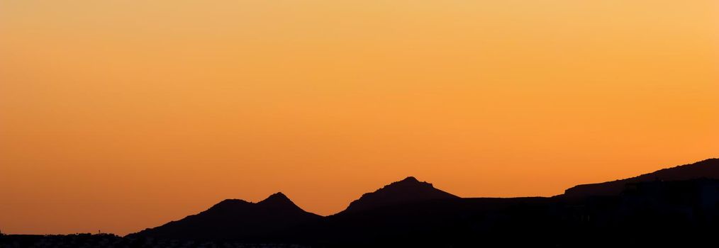 Background from a beautiful colorful sunset with the silhouette of the mountains. High quality photo