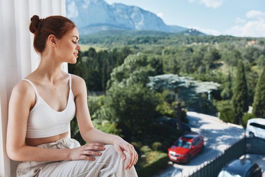 woman sitting on a balcony outdoors hotel vacation luxury. High quality photo