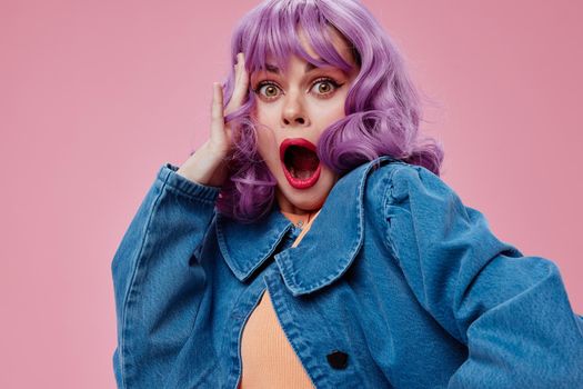 Pretty young female wavy purple hair blue jacket emotions fun pink background unaltered. High quality photo