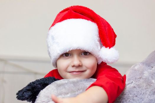 Portrait of a cute boy in a Santa Claus hat. Funny smiling child. Christmas concert.