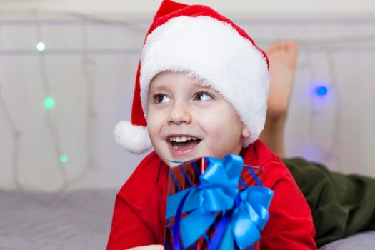 Portrait of a cute boy in a Santa Claus hat. Funny smiling child. Christmas concert.