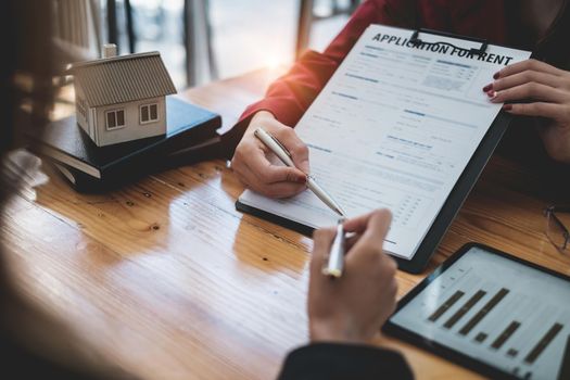 Close up of Business woman or agent pointing and signing agreement for buying house. Bank manager concept