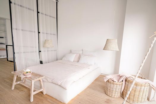 pale pink bedroom in a minimalistic style with a double bed with areas for clothes and for sleeping. High quality photo