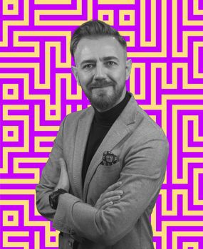 Black and white portrait of a stylish elegant senior businessman with a beard and casual business clothes against retro colorful pattern design background gesturing with hands. High quality photo