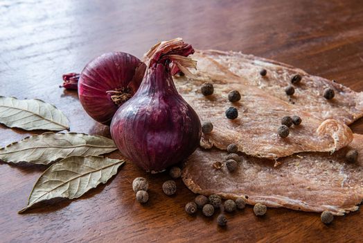 Jerky with spices, onions and herbs on an old wooden table. Beer snack.