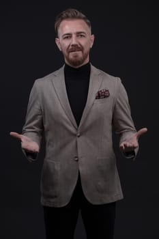 Portrait of a stylish elegant senior businessman with a beard and casual business clothes in photo studio isolated on dark background gesturing with hands. High quality photo