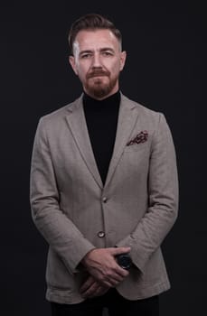 portrait of a stylish elegant businessman looking at camera in photo studio on dark background with hard light. High quality photo