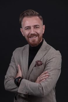 Portrait of a stylish elegant senior businessman with a beard and casual business clothes in photo studio isolated on dark background gesturing with hands. High quality photo