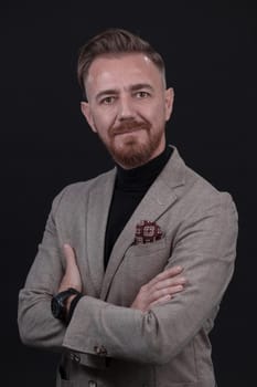 Portrait of a stylish elegant senior businessman with a beard and casual business clothes in photo studio isolated on dark background gesturing with hands. High quality photo