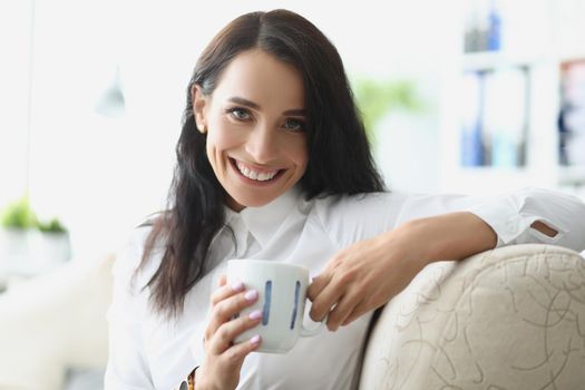Portrait of beautiful brunette young woman chilling with cup of hot drink. Pause from work or dayoff at home. Coffee break, lunch, relax, happiness concept