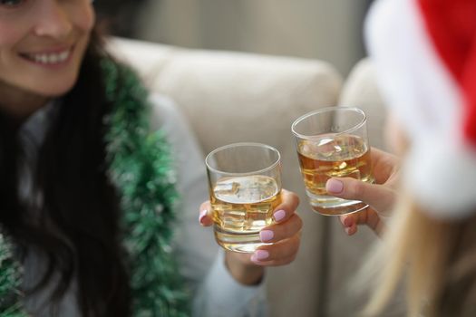 Close-up of friends drink alcoholic cocktails and celebrate new year together. Meeting after long separation with sister. Family, christmas, drunk concept