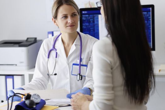 Portrait of patient on appointment explain problem to medical worker in clinic. Female doctor listen to complaints. Health, medicine, diagnostic concept