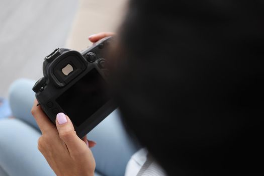 Close-up of woman hold turned off camera, black screen, not work after damage. Photographer cant see photoshot pictures. Mockup, copy space, broken concept