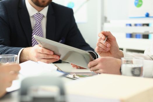 Close-up of manager holding special pen and paper tablet with document to sign. Discussing contract that determine corporation future. Strategy concept