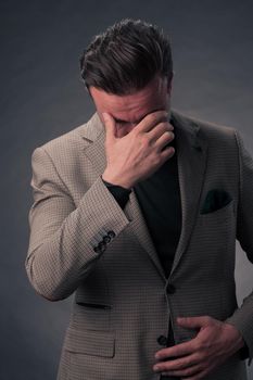 Portrait of a successful stylish elegant senior businessman with a grey beard and casual business clothes confident in photo studio isolated on dark background gesturing with hands. High-quality photo