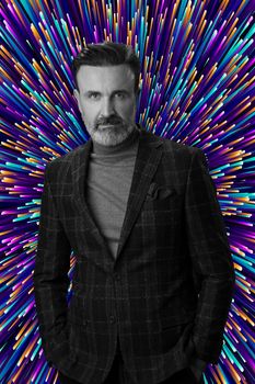 Black and white portrait of a stylish elegant senior businessman with a beard and casual business clothes against retro colorful pattern design background gesturing with hands. High quality photo