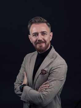 Portrait of a successful stylish elegant senior businessman with a grey beard and casual business clothes confident in photo studio isolated on dark background gesturing with hands. High-quality photo