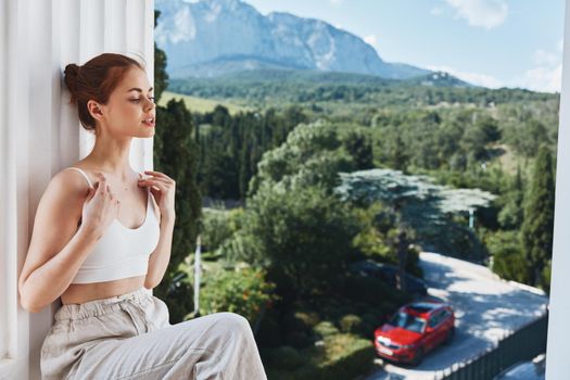 beautiful woman in white t-shirt on the balcony in the mountains. High quality photo