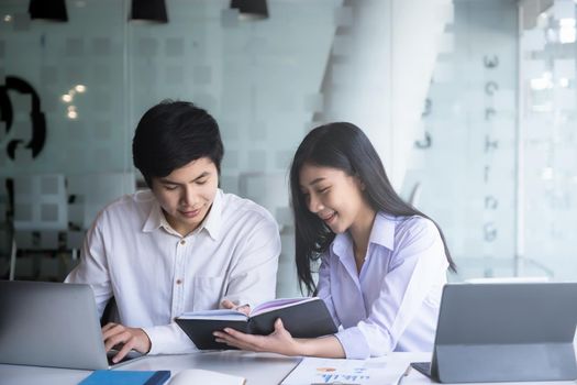 Young modern businessman and woman working together in modern co-work space. Creative concept.