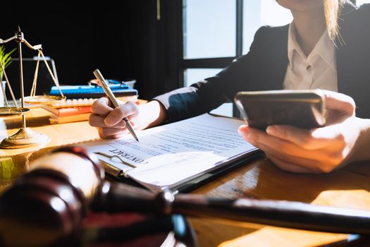 Business woman or lawyers discussing by phone with brass scale on wooden desk in office. Law, legal services, advice, Justice concept.