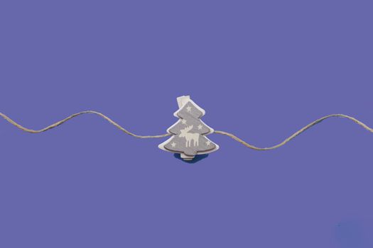 Christmas decorations decorative background. Decorative wooden white Christmas tree toy in the shape of a Christmas tree on a blue background. Top view, minimalism, flat layout