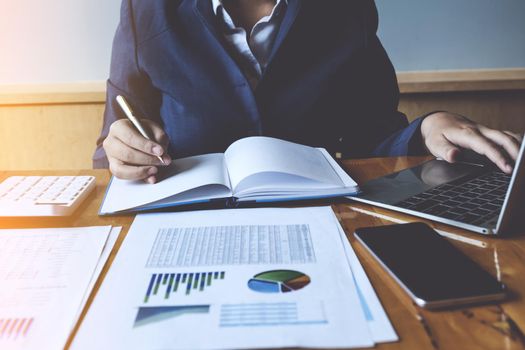 Businesswoman or Accountant hands holding pen with laptop , account and saving concept.