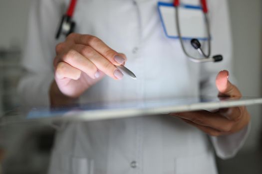 Close-up of doctor using tablet to correct patient history, modern device help in clinic work. Manage appointment, online consultation. Development concept