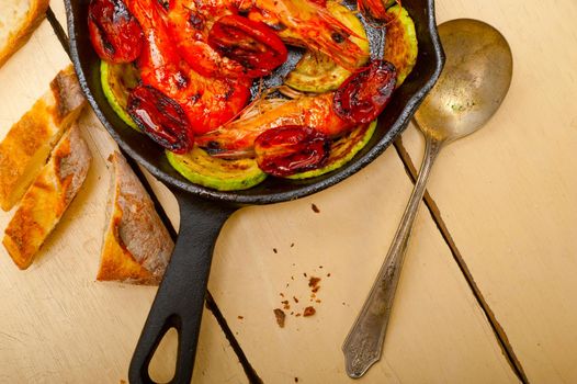 roasted shrimps on cast iron skillet  with zucchini and tomatoes