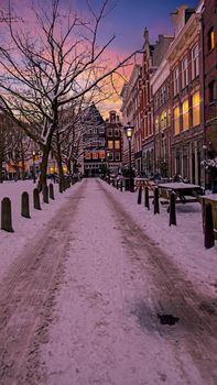 Snowy Amsterdam in winter in the Netherlands Europe at sunset