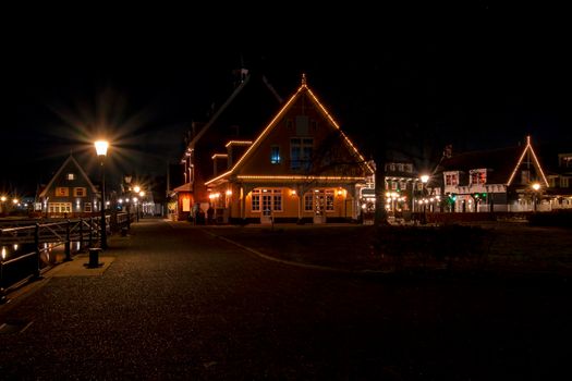 Old traditional dutch wooden houses in Friesland the Netherlands by night in christmas time