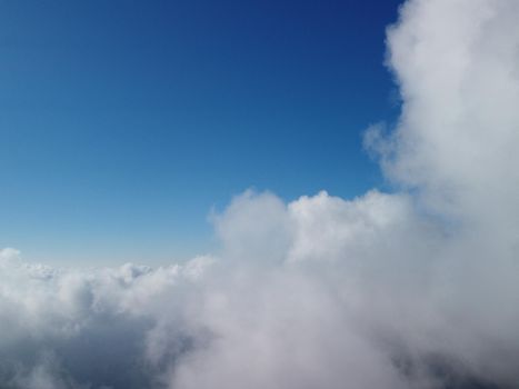 Footage B roll Aerial view drone flying above white clouds dense fog move quickly. Drone flies high back in blue sky through fluffy clouds. Beautiful foggy and cloudy slow moving Aerial view. Fog sea.