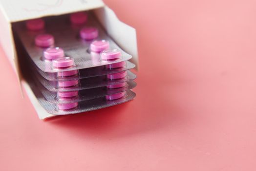 Close up of pills of blister pack on table .