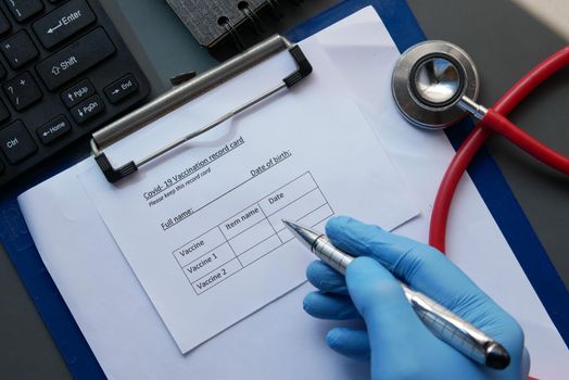 vaccination record card , hand sanitizer and mask on color background .