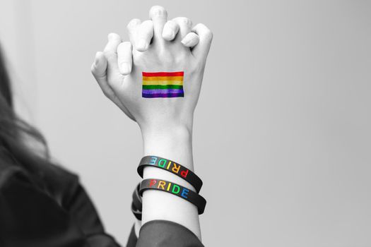 LGBTQ people couple lover hand holding together with LGBT rainbow flag sexuality freedom rights symbol.