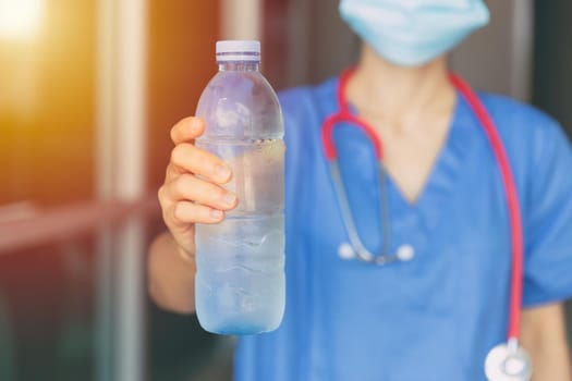 Doctor Nurse giving or recommend drinking clean cool water in hot summer for prevent dehydration.