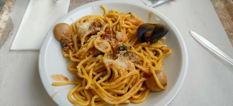 Egg spaghetti with seafood and mussels on a white plate. High quality photo