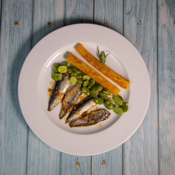 RECIPE OF SARDINE FILLETS MARINATED WITH CHILI, POLENTA WITH BEANS, SEEFOOD. High quality photo