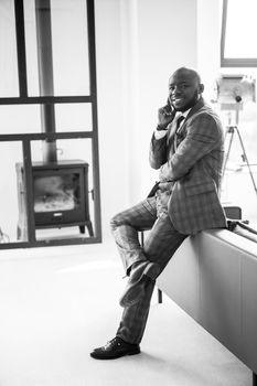 Happy And Contented Businessman. African American Man Smiling And Looking At Camera In Loft Apartment. Concept Of Rich Life, Personal Growth. Black White Photo. High Quality Photo