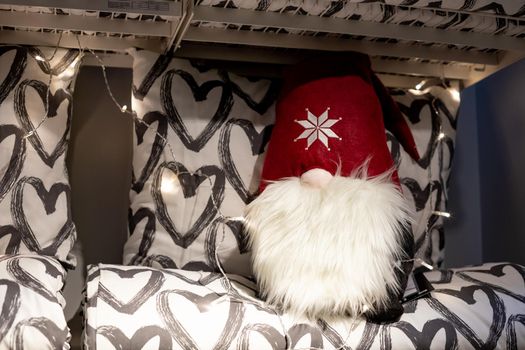 cute Scandinavian Christmas dwarf sitting on the pillows.