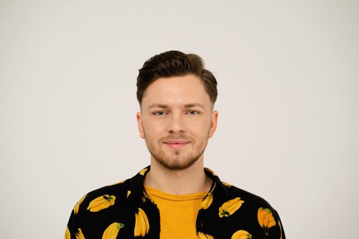 Close up portrait of handsome man in banana shirt looking at camera isolated on white background.