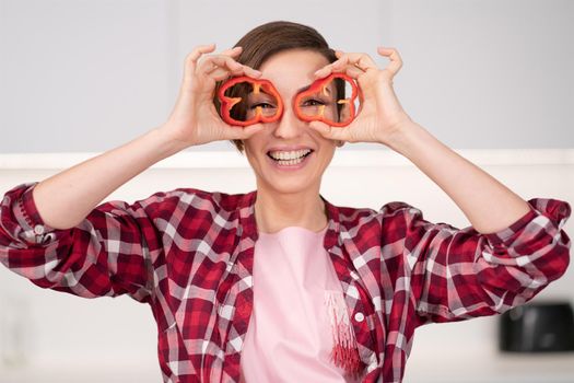 Short hair woman in red shirt playing with food, cut slices of sweet paper while cooking in the white kitchen. Healthy food at home. Healthy food leaving concept.