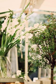 Floral wedding decoration in a restaurant outdoors in summer.