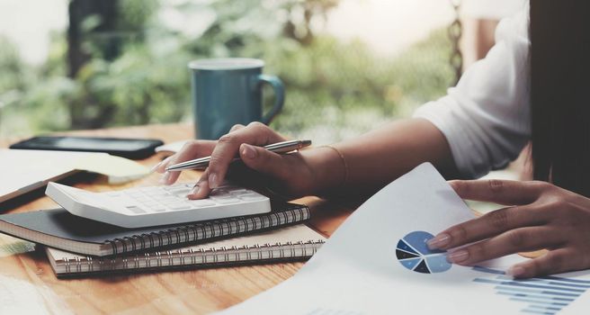 Woman accountant working with computer and calculator for business and financial expense.