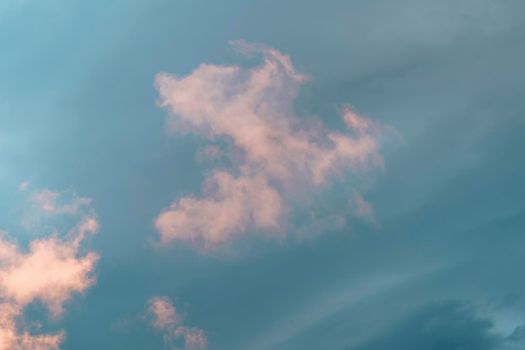 Natural background with pink clouds on a blue sky.
