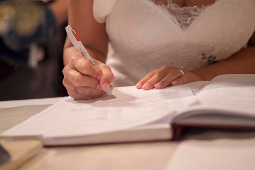 wedding bride signs register in catholic wedding. High quality photo