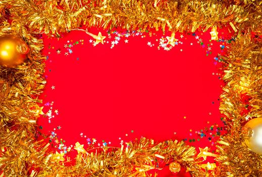 Christmas baubles with star-shaped lights and tinsel frame on red background