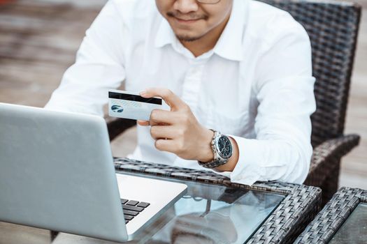 Young Handsome man enjoy shopping online on mobile phone with credit card.