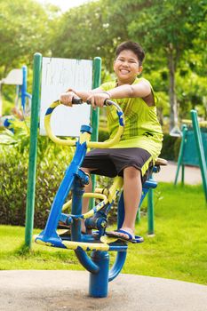 Happy asian sport boy play on swing playground in Garden