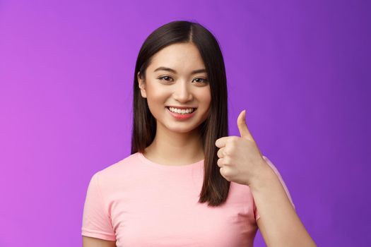 Friendly good-looking supportive asian female friend encourage you keep going, nice work, satisfied good job, smiling approval, show thumb-up gesture, grinning accepting perfect choice.